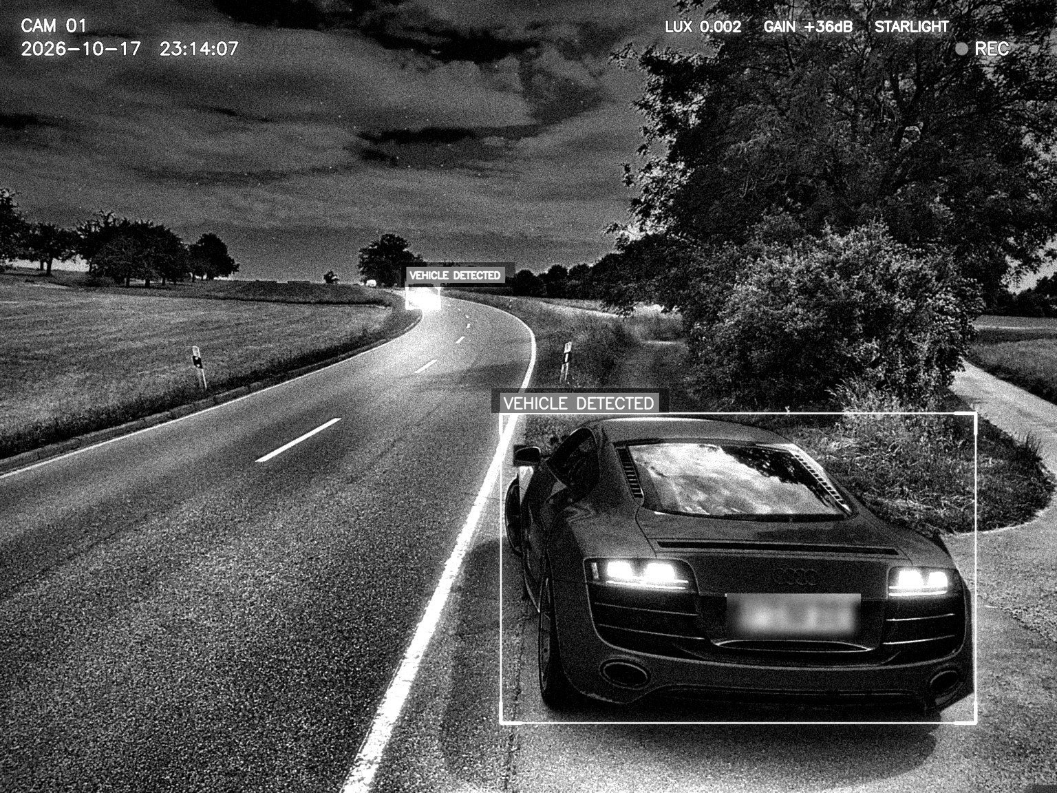 A camera view of two cars on a night road, with an AI vehicle-detected overlay, recorded in black and white by a typical infrared camera